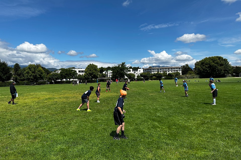 Students on the line of scrimmage before the ball is snapped at the second annual A.D. Rundle Middle School touch football tournament on June 18, 2024. 