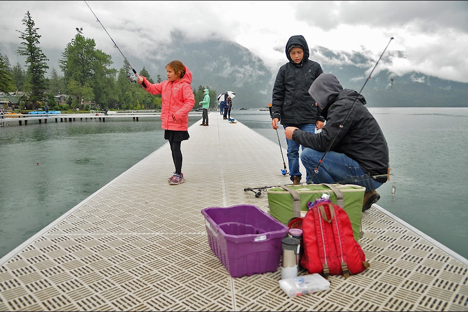 Brent Indenbosch helps 11-year-old son Cody with his fishing rod as eight-year-old daughter Kayla tries to catch another fish during the Cultus Lake Fishing Derby at Main Beach on Saturday, June 15, 2024.
