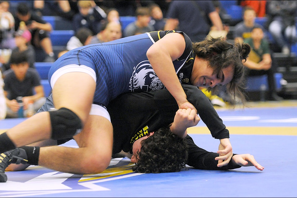 Joshua Petrel from GW Graham Secondary School (blue) competes in the third annual Chilliwack Storm Wresting Invitational at Chilliwack Secondary School on Jan. 10, 2025.