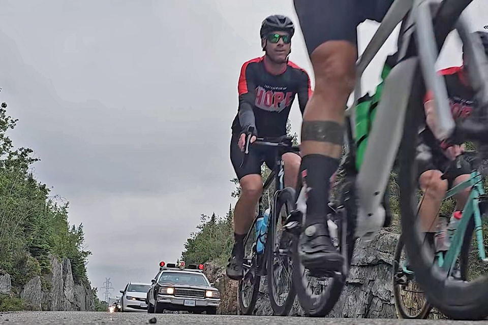 A vintage Ontario Provincial Police cruiser is seen escorting Darrell Fox's cycling team as they make their way to the Terry Fox Memorial in Thunder Bay on June 23, 2025 in this screen grab from an OPP video. 