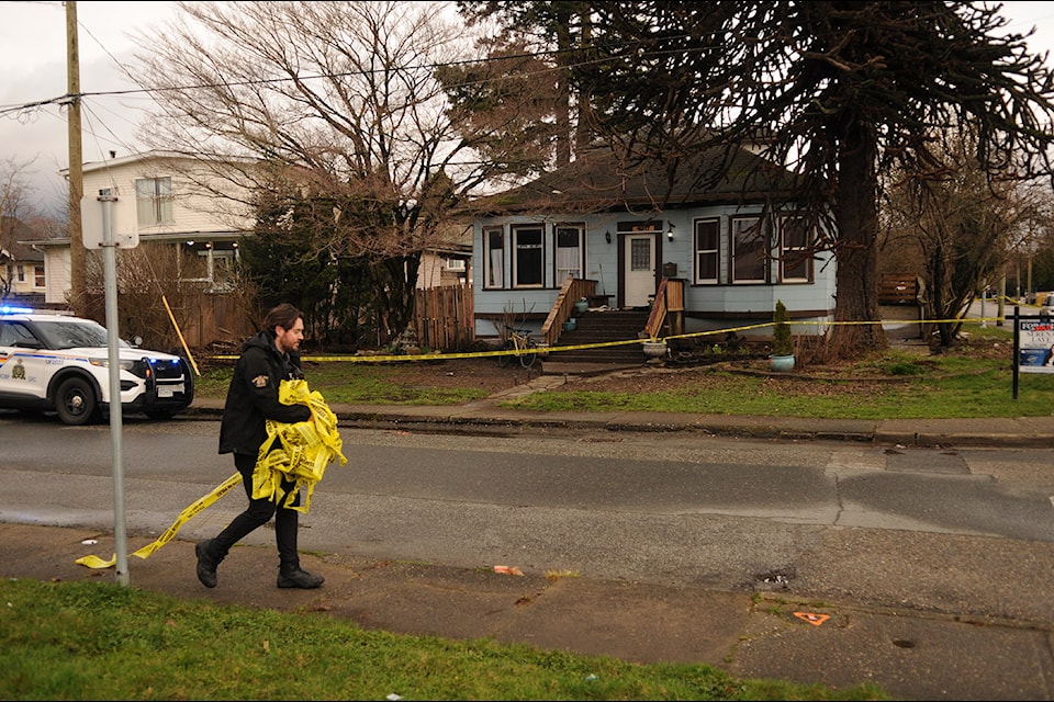 A police officer removes tape and opens up the intersection of Princess Avenue and Williams Street following a targeted shooting in Chilliwack on March 21, 2025.