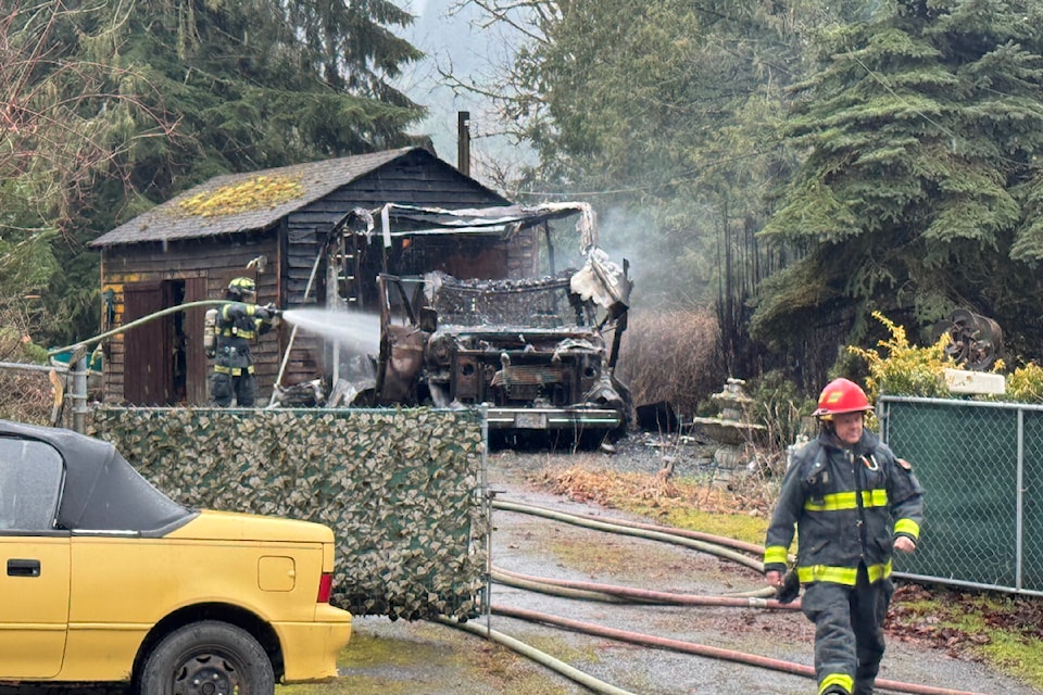 Chilliwack firefighters worked at dousing an RV fire that was threatening homes, vehicles and the surrounding forest on Winona Road on March 9. 