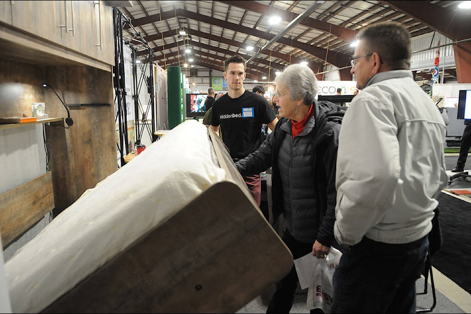 Robert Harvey (left) of Hiddenbed Canada Direct watches as a woman pulls down a bed during the 2020 Home, Leisure and Outdoor Living Expo at Chilliwack Heritage Park on Saturday, Jan. 25, 2020. (Jenna Hauck/ The Progress)