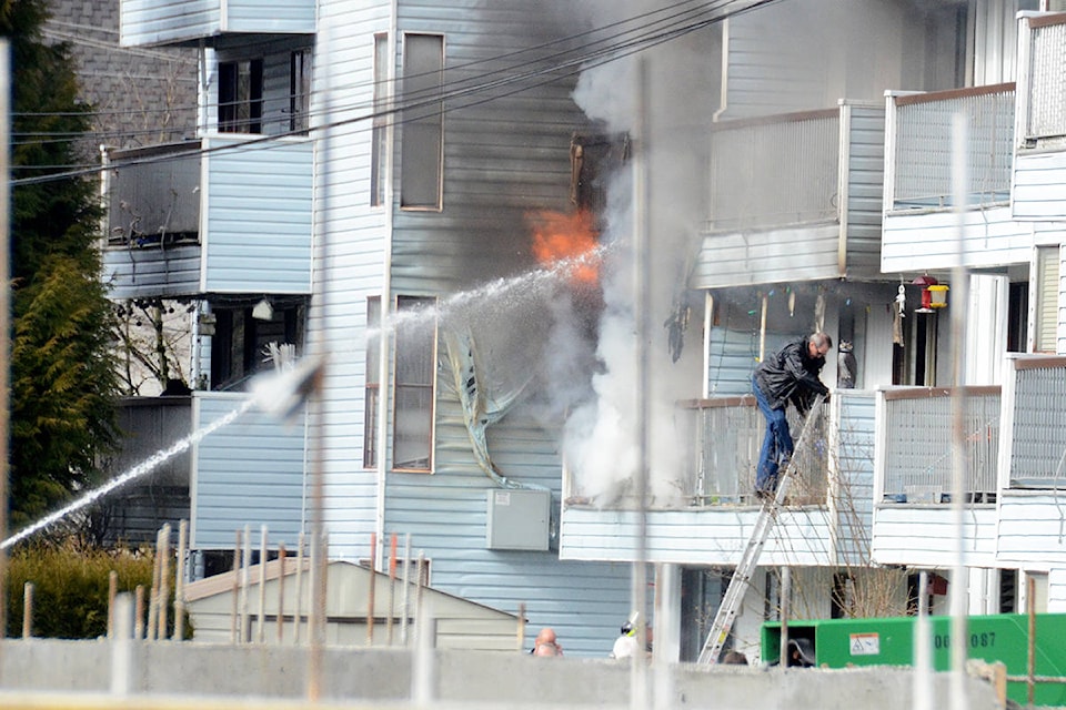 Chilliwack firefighters rescue a man using a ladder from the second floor of an apartment on fire on Cook Street on March 6, 2020. (Paul Henderson/ The Progress)