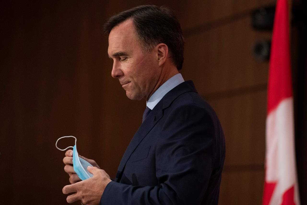 Minister of Finance Bill Morneau removes his mask as he prepares to announce his resignation during a news conference on Parliament Hill in Ottawa, on Monday, Aug. 17, 2020. THE CANADIAN PRESS/Justin Tang