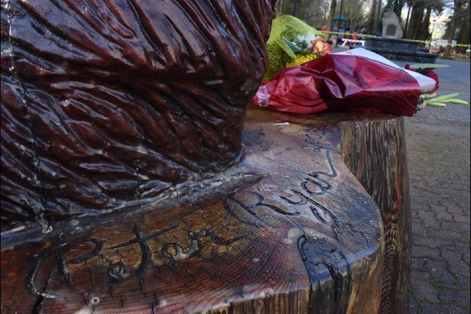 Locals laid flowers down at the foot of the big bear carving at Memorial Park, paying tribute to the late chainsaw carving legend Pete Ryan (Photo/Adam Louis)