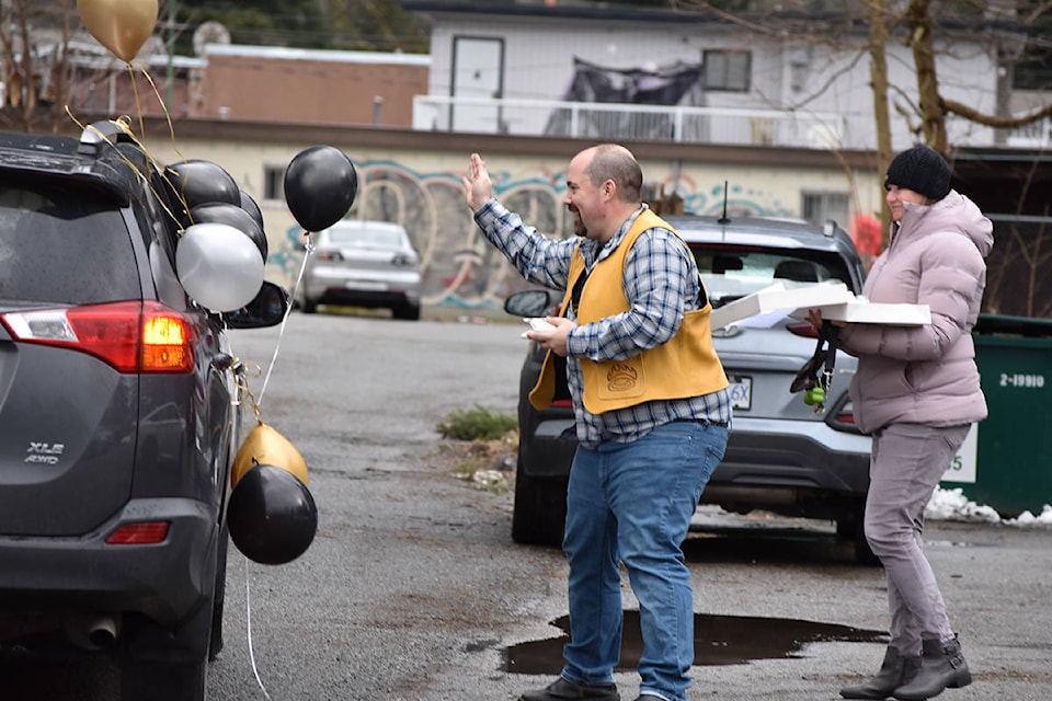 Dr. Joshua Greggain waves to a driver during a drive-thru goodbye parade at Hope Medical Centre on Friday, Feb. 26. Greggain gave out cookies bearing his likeness to parade-goers. (Photo/Adam Louis)