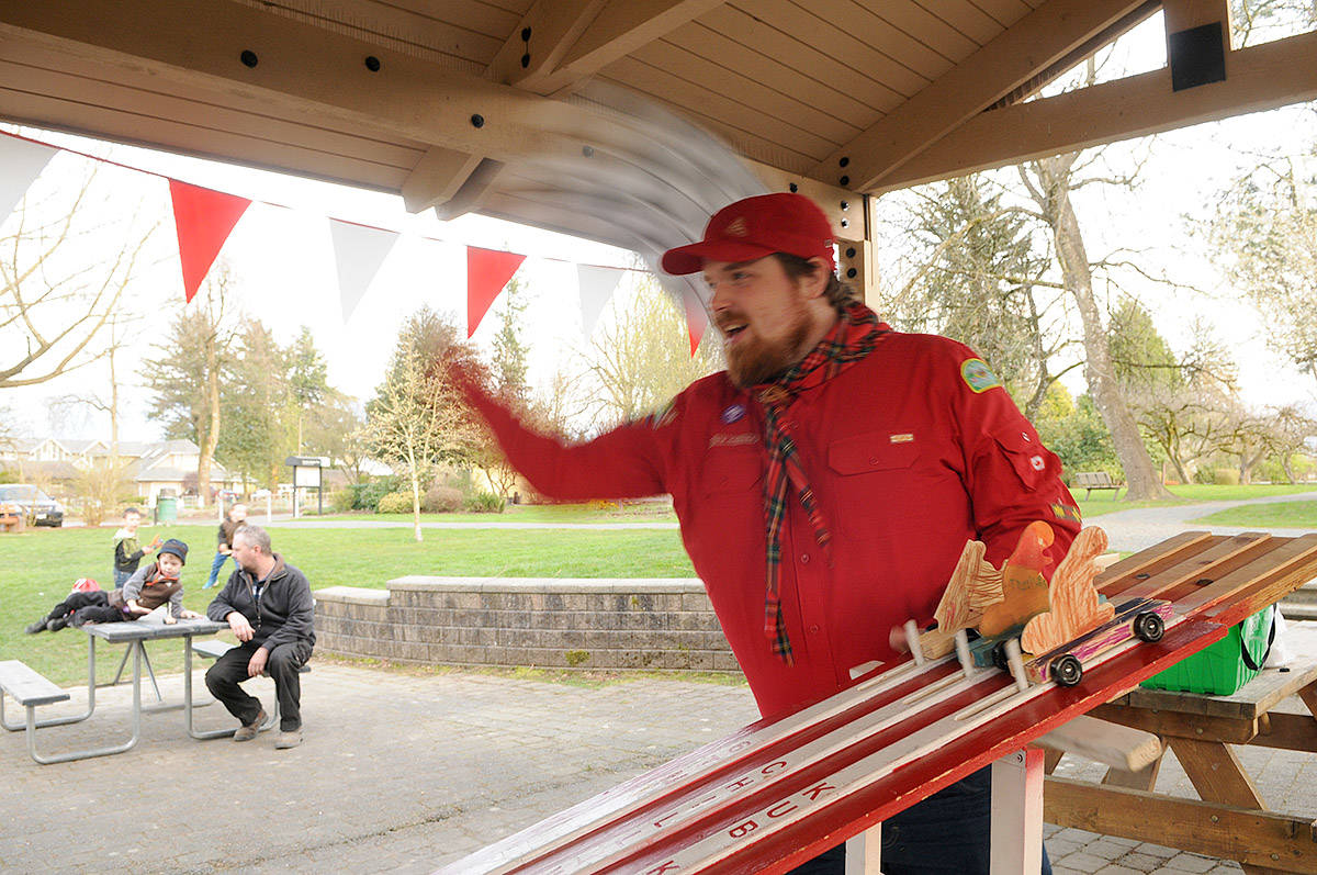 Brent Hunter, Beaver Scout, waves a checkered flag as he launches three Beaver Buggies during a race at Gwynne Vaughan Park on Tuesday, April 6, 2021. (Jenna Hauck/ Chilliwack Progress)