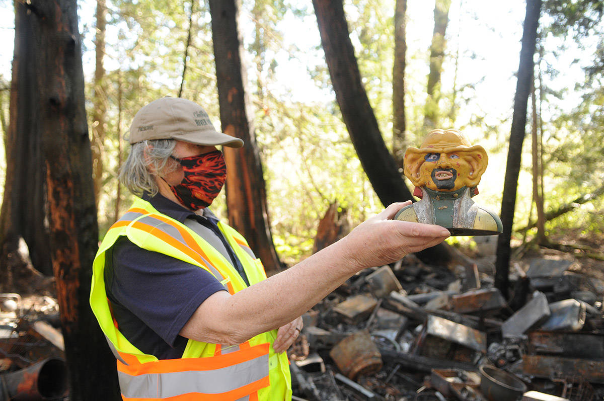 Chris Gadsden holds up a Star Trek Quark figure head – one of the few items not burned in a homeless camp fire in the Chilliwack River Valley. (Jenna Hauck/ Chilliwack Progress)