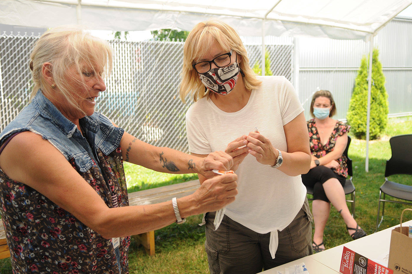 Kim Lloyd (left), program supervisor with Pacific Community Resources Society (PCRS) in Chilliwack, shows Candice Quesnel how to quickly open a syringe package during a free friends and family naloxone training workshop at Chilliwack Health and Housing Centre on Tuesday, June 22, 2021. (Jenna Hauck/ Chilliwack Progress)