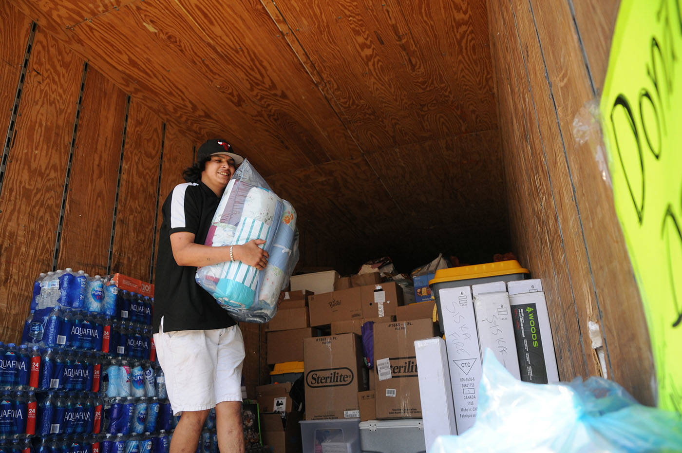 Volunteer Christopher Raweater helps load a semi trailer during a donation drive for wildfire victims in the old Sears parking lot at Cottonwood Centre on Saturday, July 3, 2021. (Jenna Hauck/ Chilliwack Progress)