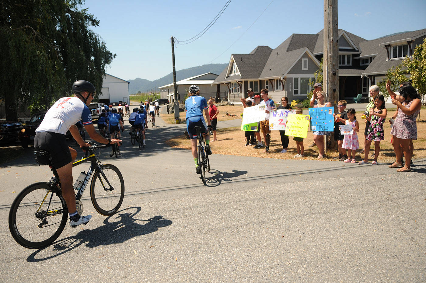 People cheer on the Fraser Valley Try Like Terry team including during the Ride of Hope on the border of Chilliwack and Abbotsford on Saturday, July 3, 2021. (Jenna Hauck/ Chilliwack Progress)
