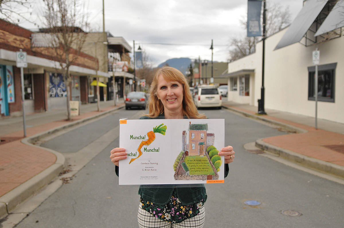 Annette Williams with Chilliwack Learning Society holds up one of the pages of Muncha! Muncha! Muncha! by Candace Fleming, a story chosen for the downtown StoryWalk event in March 2021. (Jenna Hauck/ Chilliwack Progress file)