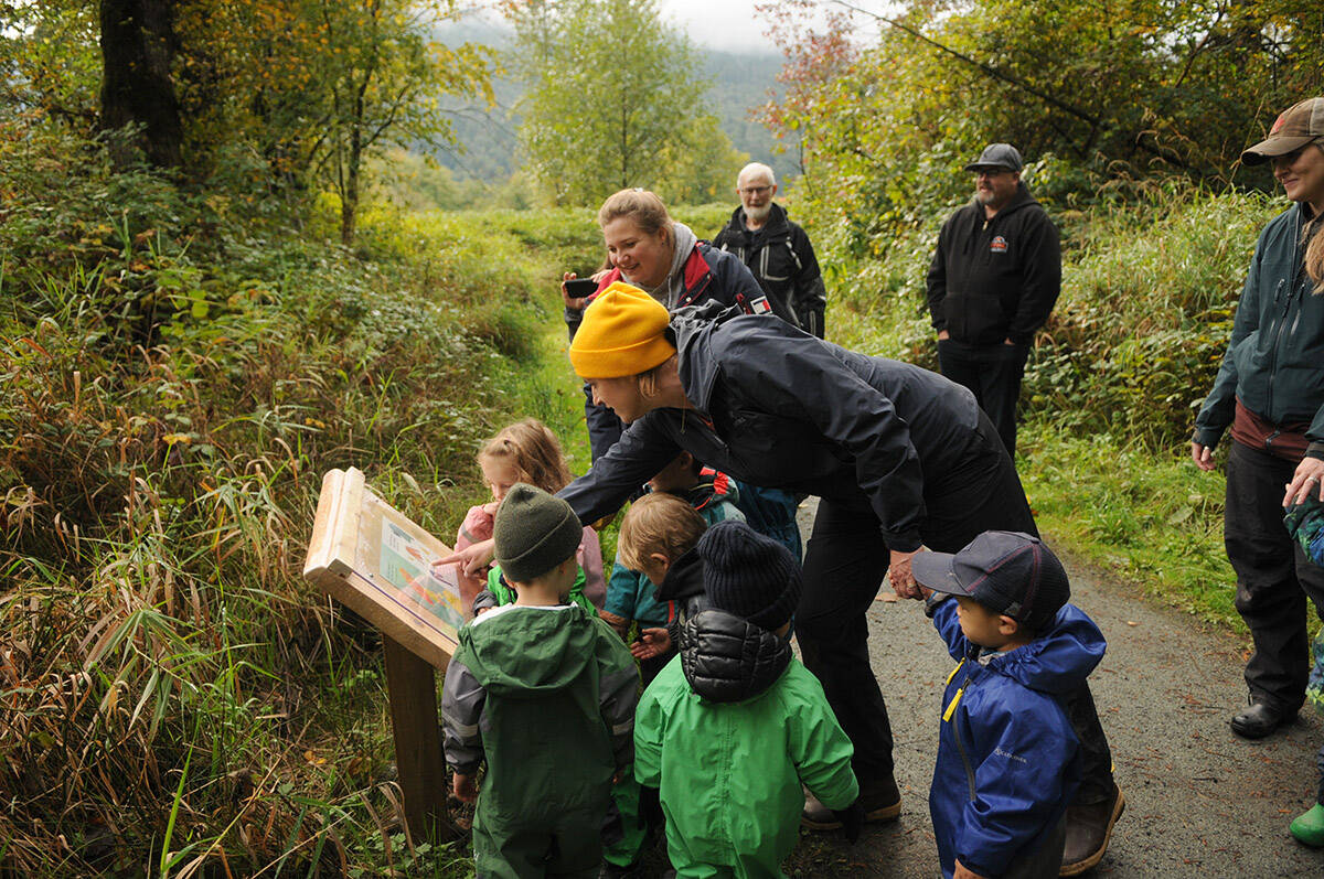 Nadine Knelsen (yellow hat), owner of Leap for Joy Open Air Learning, reads a story to preschoolers during the launch of the Yarrow StoryWalk along the Beaver Loop Trail by the Vedder River in Yarrow on Thursday, Oct. 7, 2021. (Jenna Hauck/ Chilliwack Progress)