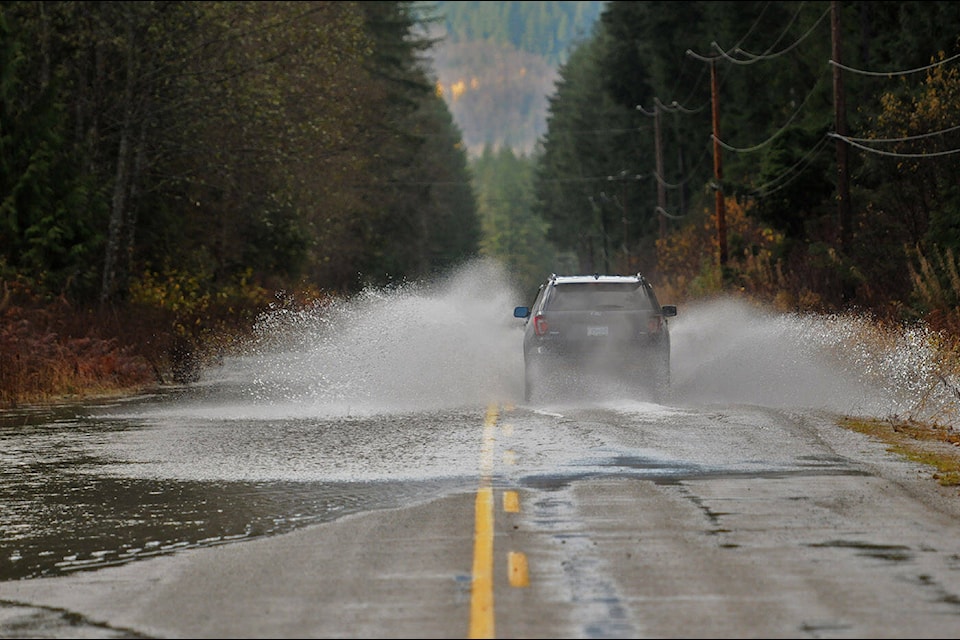 A vehicle drives through Pierce Creek as it flows across Chilliwack Lake Road on Friday, Nov. 19, 2021. (Jenna Hauck/ Chilliwack Progress)