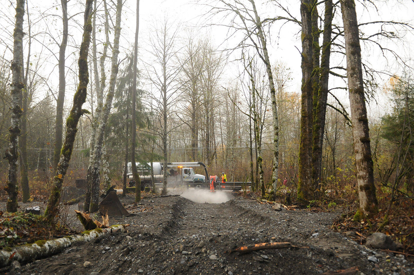 Crews from Valley Waste and Recycling blast water to remove rocks and debris from underneath the Pierce Creek Bridge on Friday, Nov. 19, 2021. (Jenna Hauck/ Chilliwack Progress)