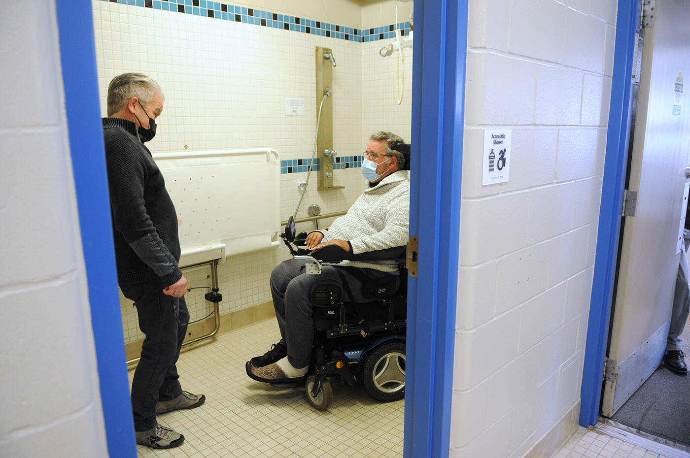 Jim Ryan (right) and Mayor Ken Popove chat during a tour of the Cheam Leisure Centre on Wednesday, Nov. 10, 2021. Ryan was pointing out some of the features at the centre that earned it the Rick Hansen Foundation Accessibility Certified Gold rating, like this accessible shower with a lift. (Jenna Hauck/ Chilliwack Progress)