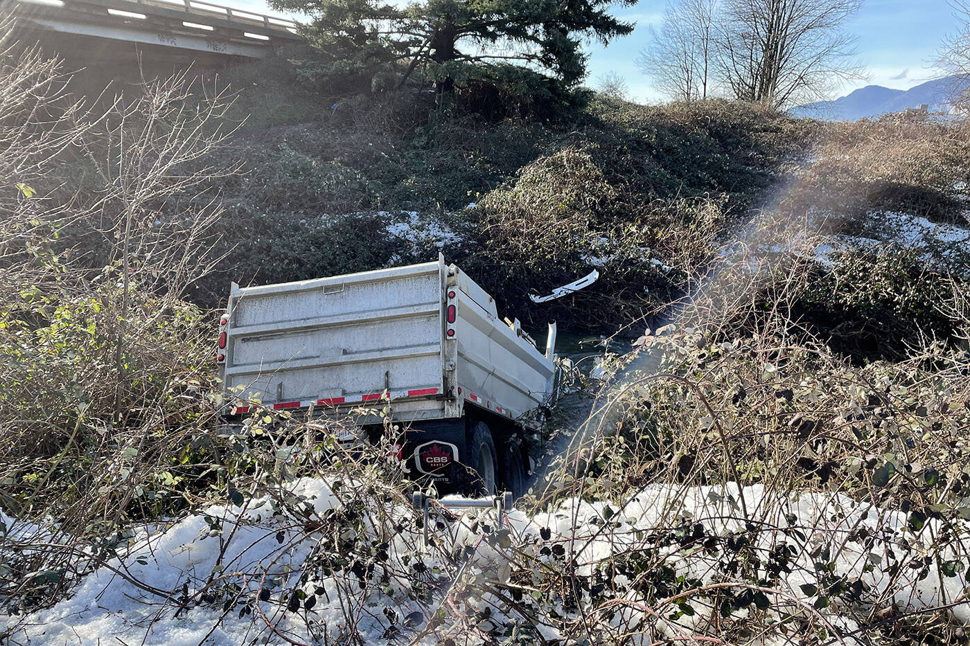 This dump truck landed in a ditch filled with frigid water after it left the Highway 1 offramp at Young Road on Friday, Jan. 14, 2022. (Cheryl Calhoun)