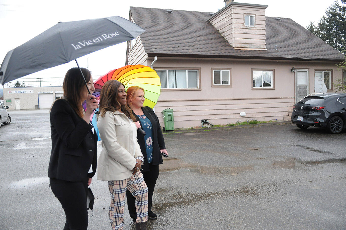 From left, Minister of State for Childcare, Katrina Chen, founder of Unique Get Together Society, Debra Abraham, and Chilliwack-Kent MLA Kelli Paddon pose for a photo outside the house on First Avenue in Chilliwack where a new childcare centre will be built. (Jenna Hauck/ Chilliwack Progress)