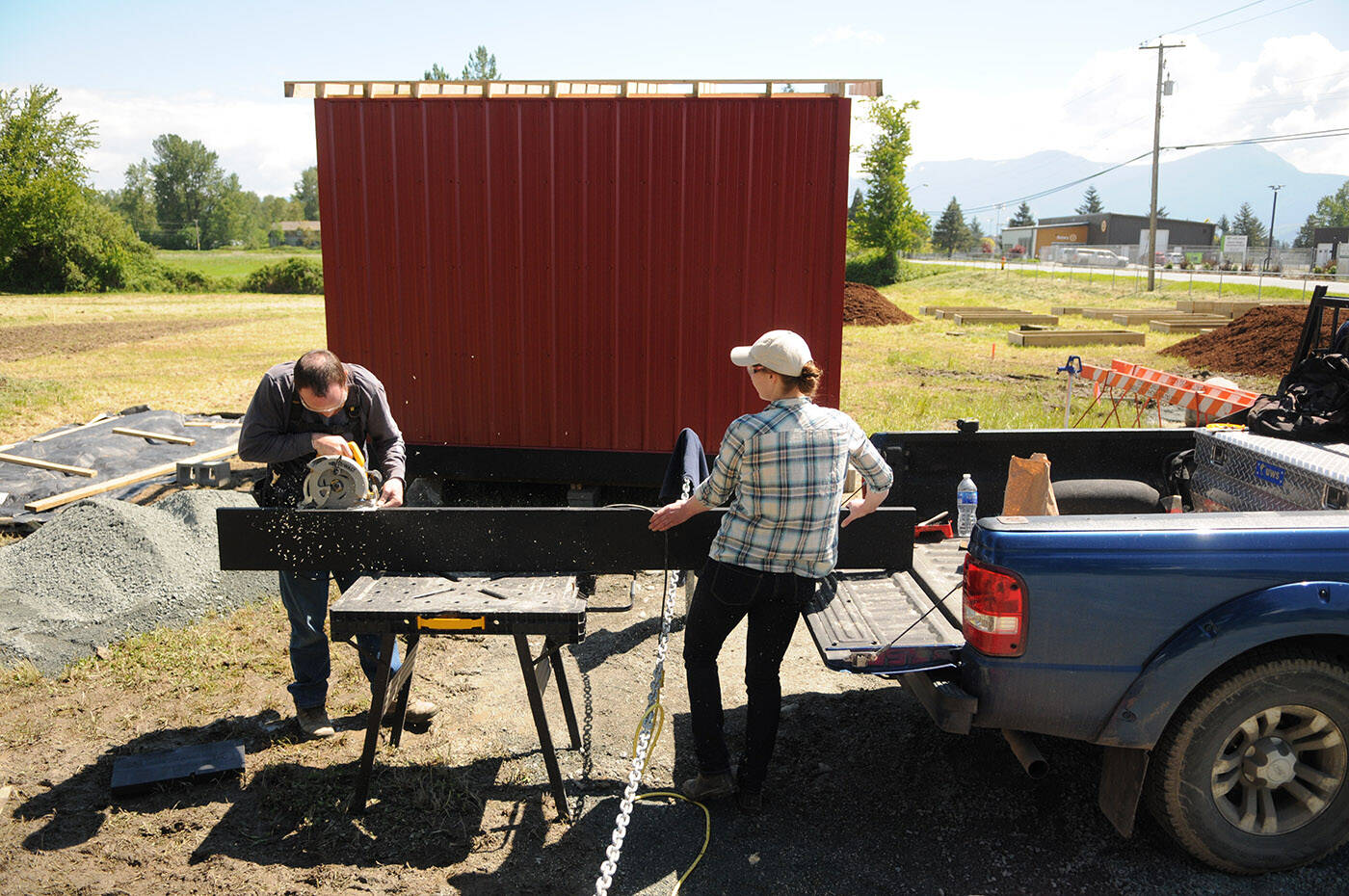 Stewart Fuoco, president of the UFV Agriculture Student Association and volunteer Julia Tuytel help build a shed at the new Bowls of Hope community garden on Wolfe Road on Friday, May 20, 2022. (Jenna Hauck/ Chilliwack Progress)