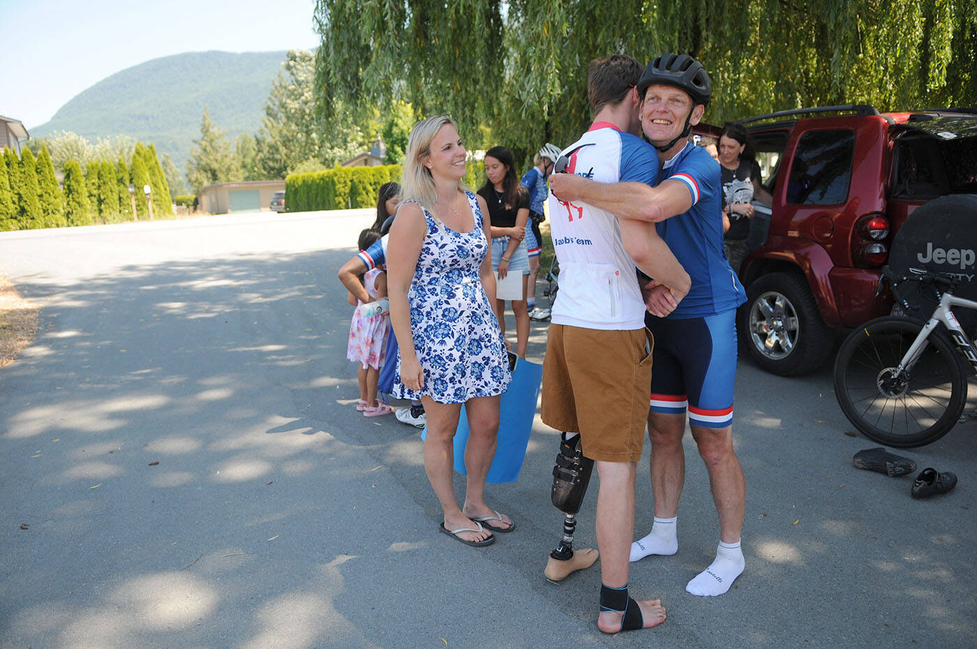 Sixteen-year-old Jacob Bredenhof (centre) hugs Darrell Fox, Terry Foxs brother, during the Ride of Hope on the border of Chilliwack and Abbotsford on Saturday, July 3, 2021. (Jenna Hauck/ Chilliwack Progress file)