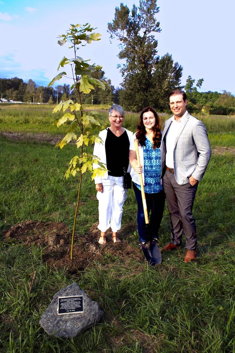 From left Cindy Waters, executive director with Chilliwack Bowls of Hope Society, Michelle Csoka (wife of Mike Csoka) and Chris Csoka (Mikes son) stand by the maple tree that was planted and dedicated to Mike Csoka, one of the founders of Chilliwack Bowls of Hope Society on Monday, July 18, 2022. (Submitted by Chilliwack Bowls of Hope Society)
