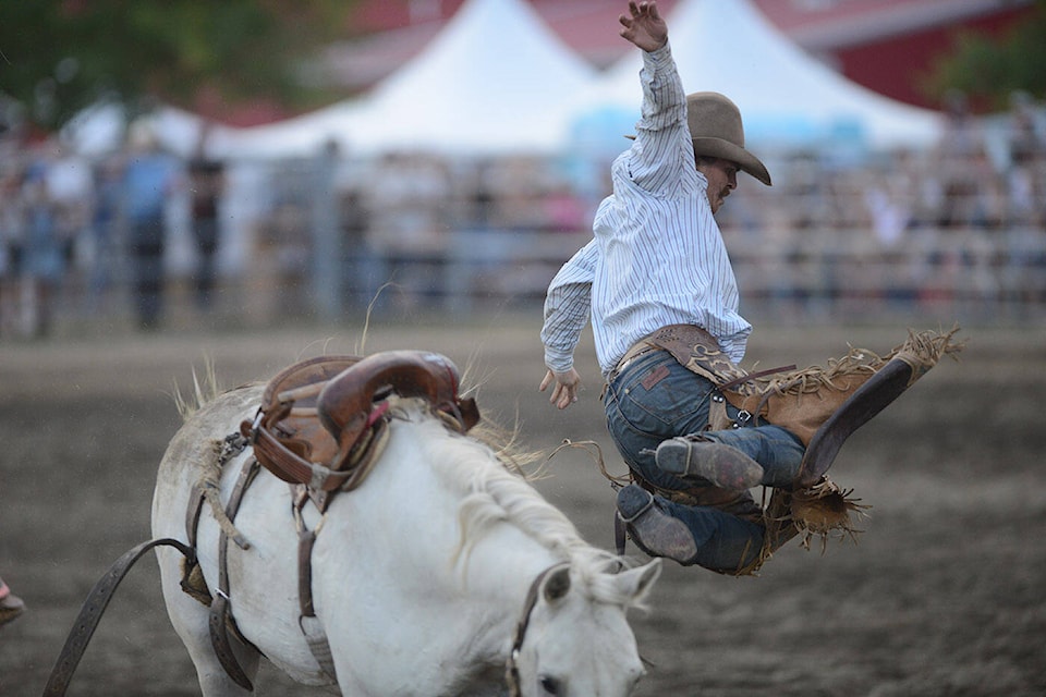 Ryan-Spur Reid jumps from ‘American Woman’ after a successful eight-second ride in the saddle bronc event at the Chilliwack Rodeo during the 151st annual Chilliwack Fair on Friday, Aug. 11, 2023. The ride earned him 80 points. (Jenna Hauck/ Chilliwack Progress)