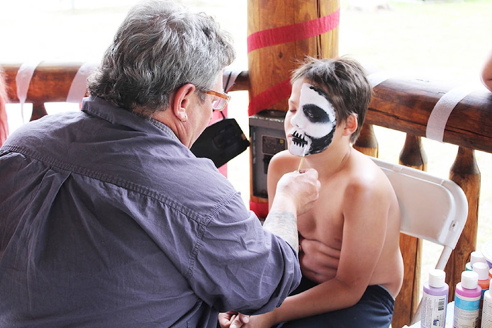 Scotty Bourgogne transforms a youngster into the Grim Reaper at the Blue River Canada Day celebrations. Photo by Jaime Polmateer