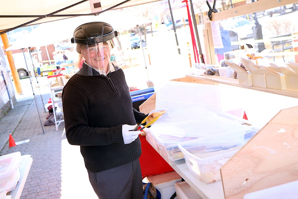 Johan Raes smiles while helping a customer at the South Cariboo Farmer’s Market on May 8. (Patrick Davies - 100 Mile Free Press)