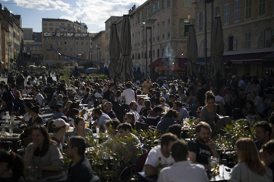 People drink outdoors on bar terraces in Marseille southern France, Wednesday, May 19, 2021. Cafe and restaurant terraces reopened Wednesday after a pandemic shutdown of more than six months deprived people of what feels like the essence of life in France. (AP Photo/Daniel Cole)