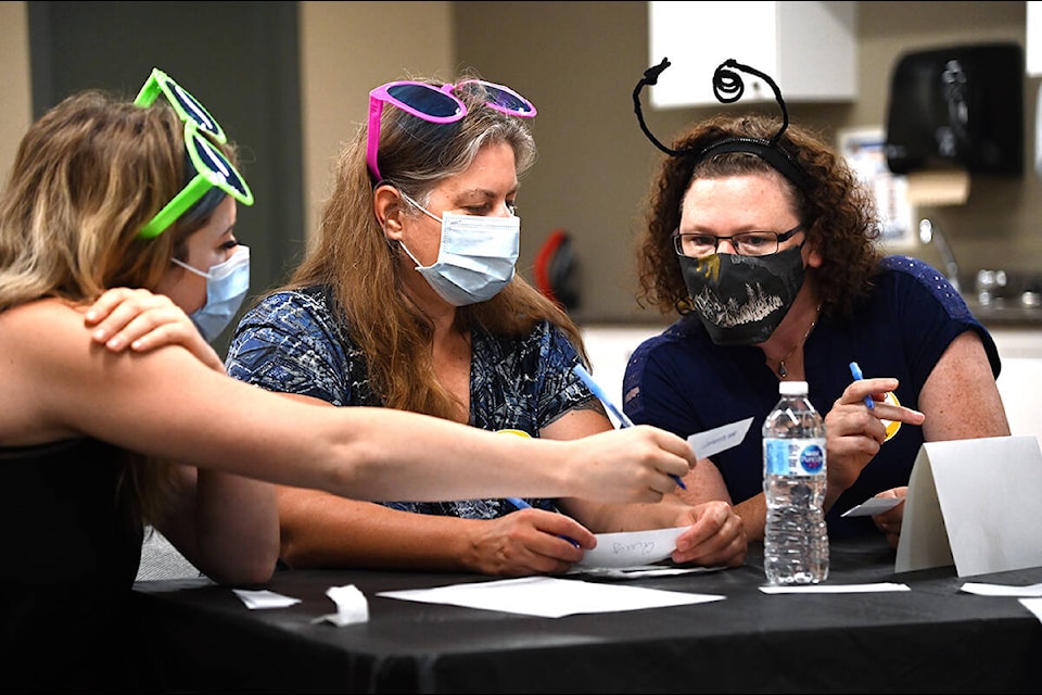 Alysha Piva, left, Nikki Vincent and Jenna Wilson compare notes as they work together to spell the word quay at the 2021 Raise-a-Reader Adult Spelling Bee held at the Dutch Lake Community Centre on Sept. 22. (Stephanie Hagenaars/Clearwater Times)
