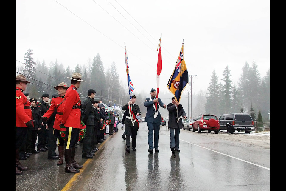 Members of the colour party march through light rain to get into position for the start of the parade to Reg Small Park during Remembrance Day ceremonies in 2011. In the color party are (l-r) Cadet Sgt. Austin Greene, RCAF Master Corporal James Robertson and Korean War veteran Bob Freeston. (Keith McNeill photo)