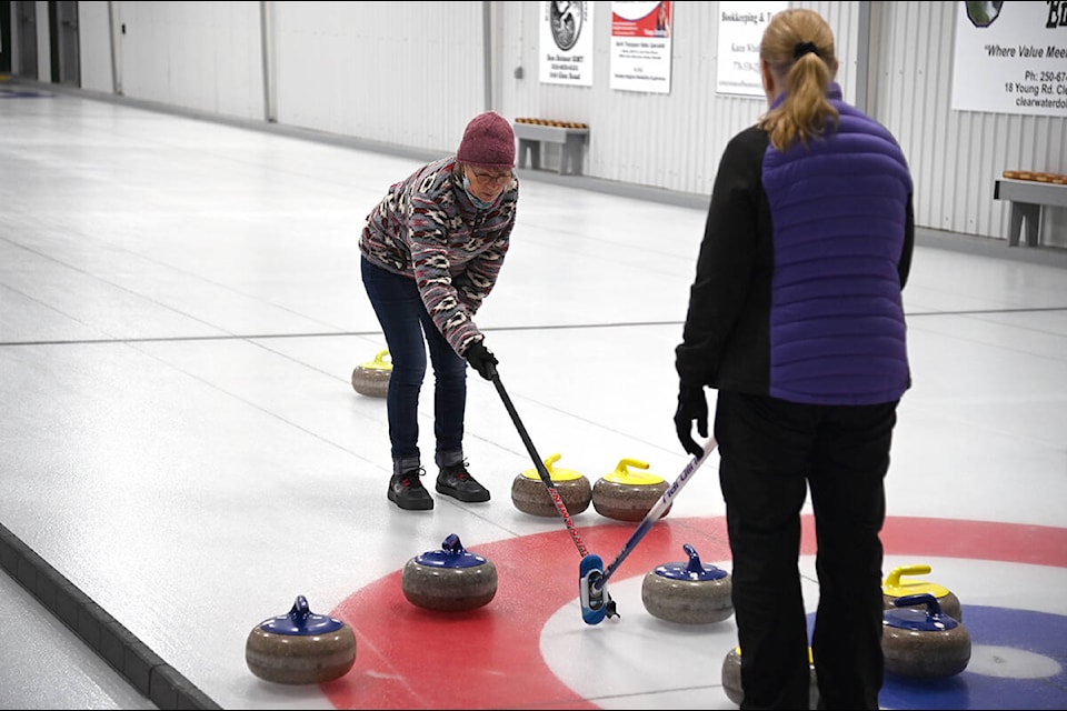 Cathy Sauer, left, and Lori Redman discuss strategy during a curling match. (Stephanie Hagenaars/Clearwater Times)