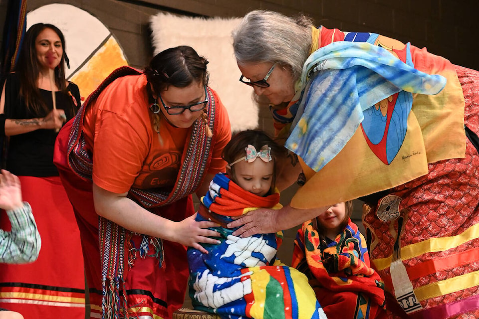 Liv is blanketed by Eagles Nest Aboriginal Head Start staff Brigette MacDougall, left, and Elder Sheila Nyman during the group’s graduation ceremony held Tuesday, June 21, at the Dutch Lake Community Centre. The blanket ceremony is performed to signify a right of passage or major achievement. Six kids from the Eagles Nest graduated this year and will be attended Kindergarten in the fall. (Stephanie Hagenaars photo)