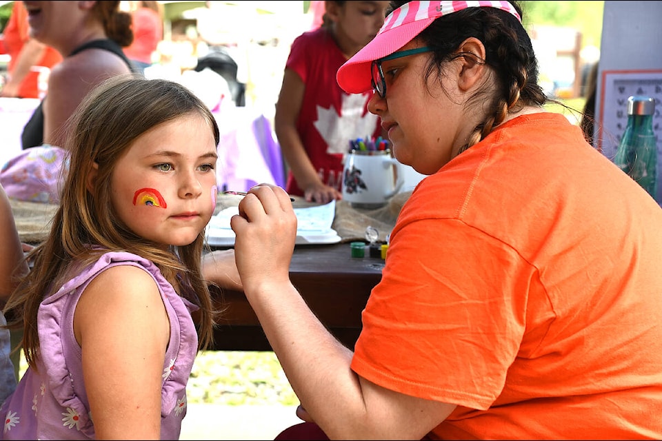 Olivia Mackenzie, 6, gets a rainbow and heart painted on her face by Brigette MacDougall on Friday for Canada Day. (Stephanie Hagenaars photo)