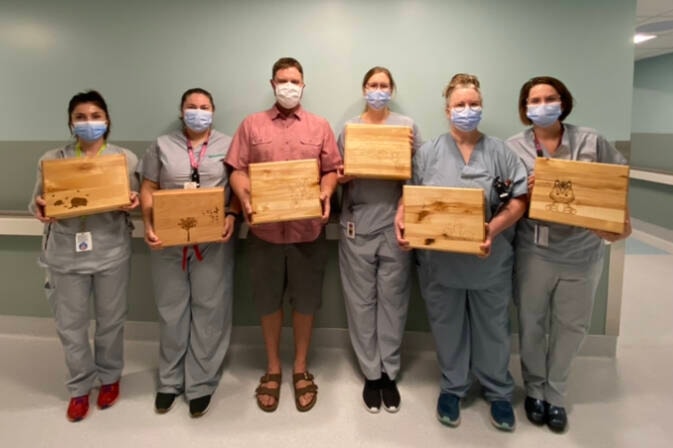 The Royal Inland Hospital labour and delivery nurses show of the memory boxes presented to them by Clearwater Secondary School teacher Dayton Fraser, centre, on behalf of his senior woodworking student. (Submitted photo)