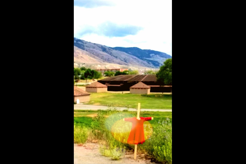 A child's red dress staked along the highway in front of the Tk'emlúps te Secwépemc First Nation in remembrance of the over 200 children lost and in honour of missing and murdered Indigenous women and girls. 