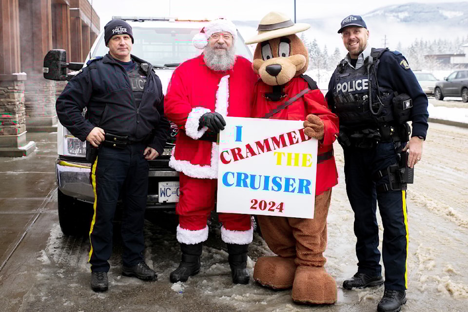 Clearwater RCMP and Victim Services coordinated the Cram the Cruiser event on Saturday, Dec. 7 to benefit the Clearwater and District Food Bank in the Buy-Low parking lot. (From L - R): Sgt. Grant Simpson, detachment commander, Santa, RCMP Safety Bear, and Cpl. Meyer.