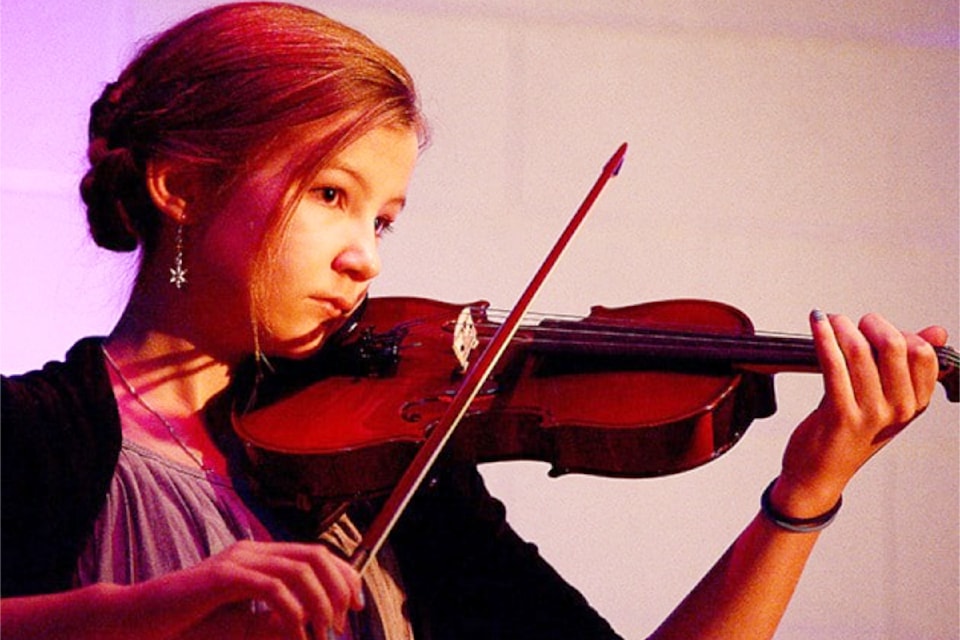 Josee Cooperman plays the violin during a performance by the Clearwater Strings at the annual Clearwater community Christmas concert. The event was held Saturday evening in the Dutch Lake Community Center.