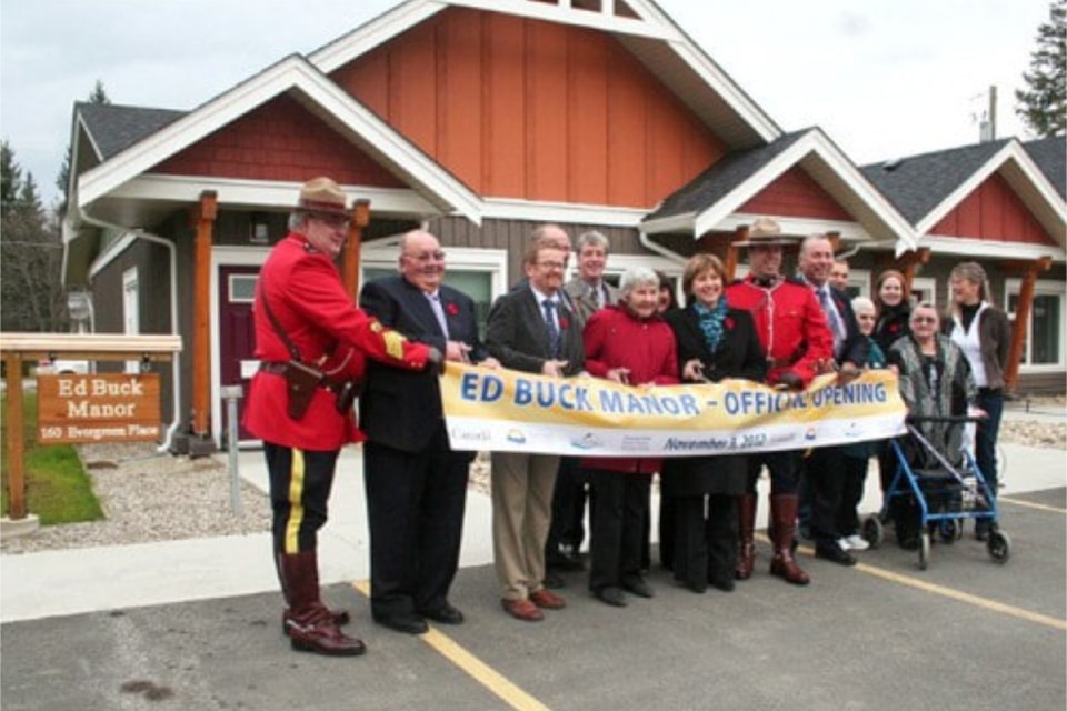 (From L – R) Sgt. Mike Savage, mayor John Harwood, MLA Terry Lake, (behind) Brent Buck, Drake Smith, Hettie Buck, (Front L-R) Eva Buck, Premier Christy Clark, Const. Joshua Buck, Barry Buck, Storm Buck, Courtney Buck, Goldie Krawec, Jean Gross and Bev Buck during the dedication of Ed Buck Manor on Nov. 9, 2012.