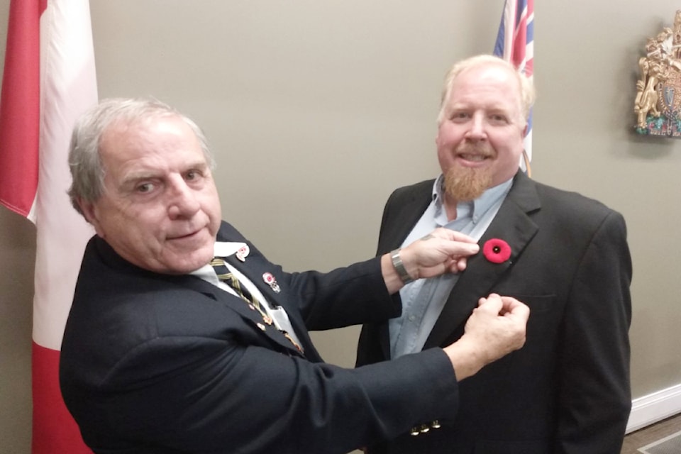 (From L - R): Comrade Wayne Wysoski, vice president of the Royal Canadian Legion branch 259 pinning the first poppy to mayor Merlin Blackwell on Oct 22, 2024. 