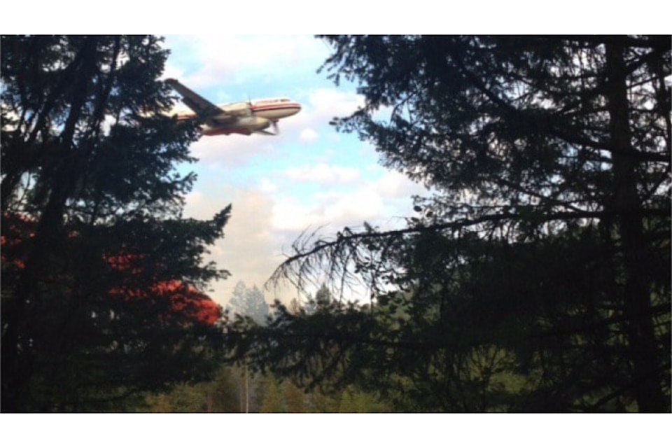 A bomber drops retardant on a fire off Tillicum Road in the BX-Swan Lake region on Tuesday evening (July 21, 2015).