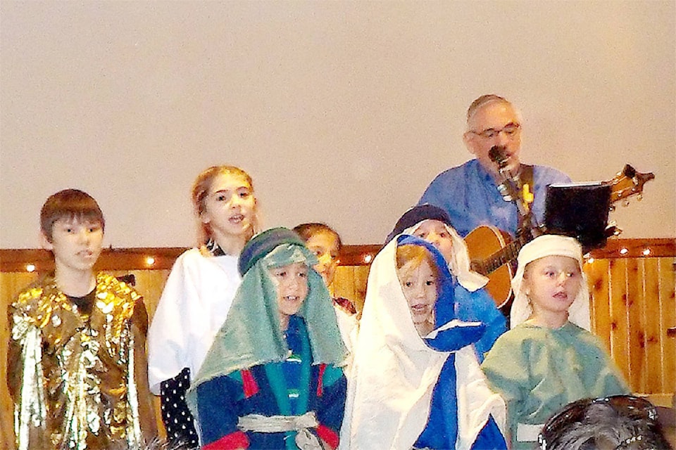 Children sing “Come on, Ring Those Bells” during Christmas in the Village at Vavenby Christian Church on Dec. 10. Pictured are (back, l-r) Hudson Wilkinson, Presley Dowds, Zion Grant, Ethan Meidl, (front, l-r) Nevaeh Grant, Cate Lin Tourond and Kelsey Rexin. John Gerber accompanies them on guitar. 