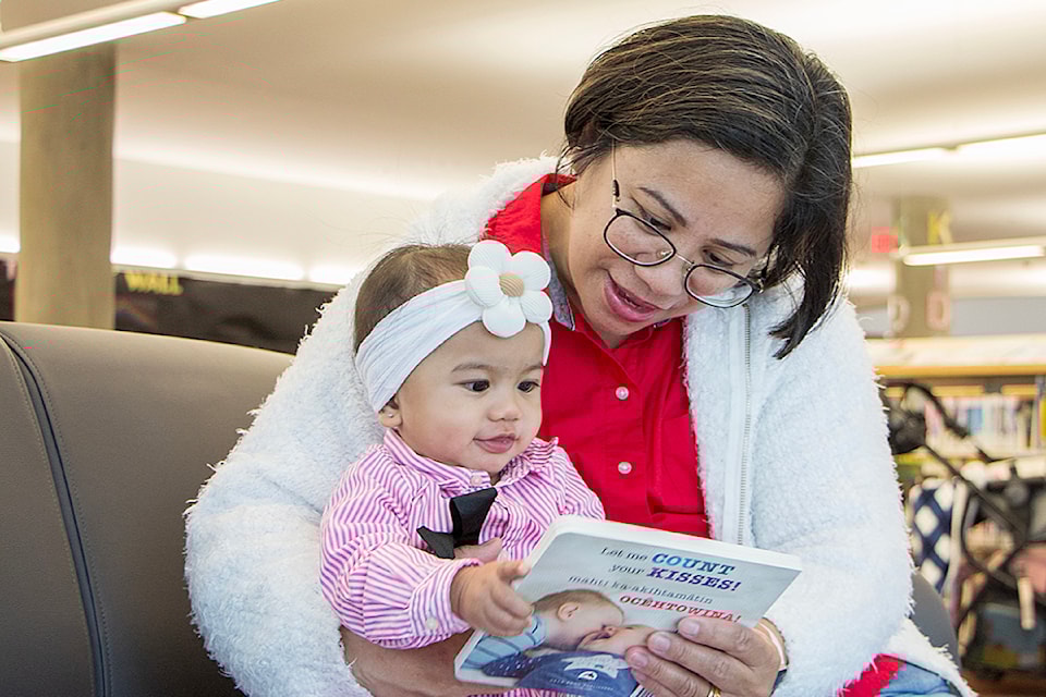 Mum Clarissa reads to baby Alyssa from a book included in Surrey Libraries' "Read to Baby" kits. The decade-long initiative is once again underway in the month of October.