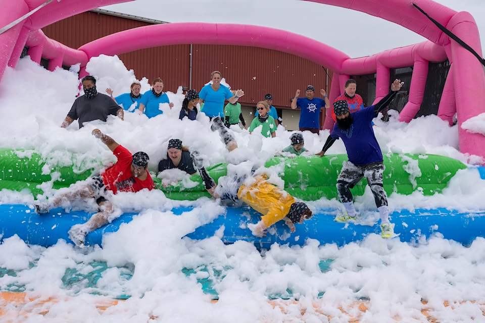Participants nearly faceplant as they lollop through one of many obstacles during the 5K Foam Fest race held on the Cloverdale Fairgrounds June 14.