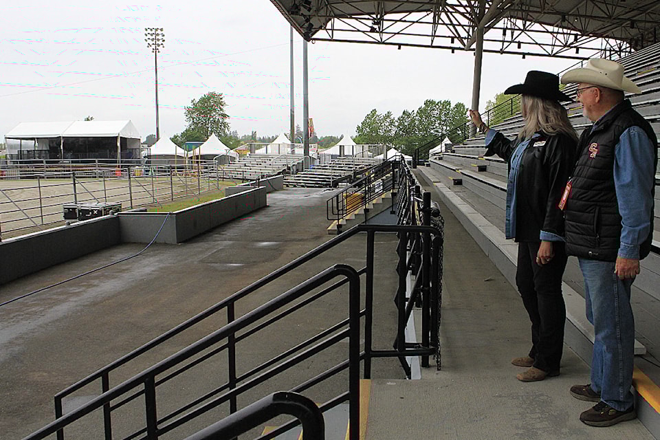 Kathy Sheppard, Cloverdale Rodeo and Exhibition Association president, and Gerry Spielmacher, the association's past president, discuss the Mustang Lounge, a new VIP viewing area seen at the left of the image.