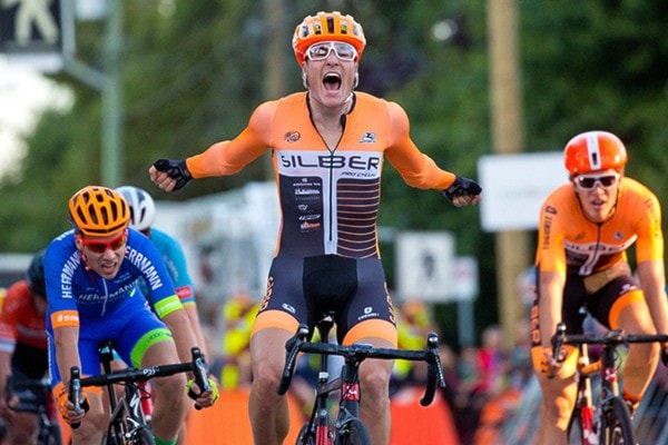 the winner of the mens' race reacts as he crosses the line.