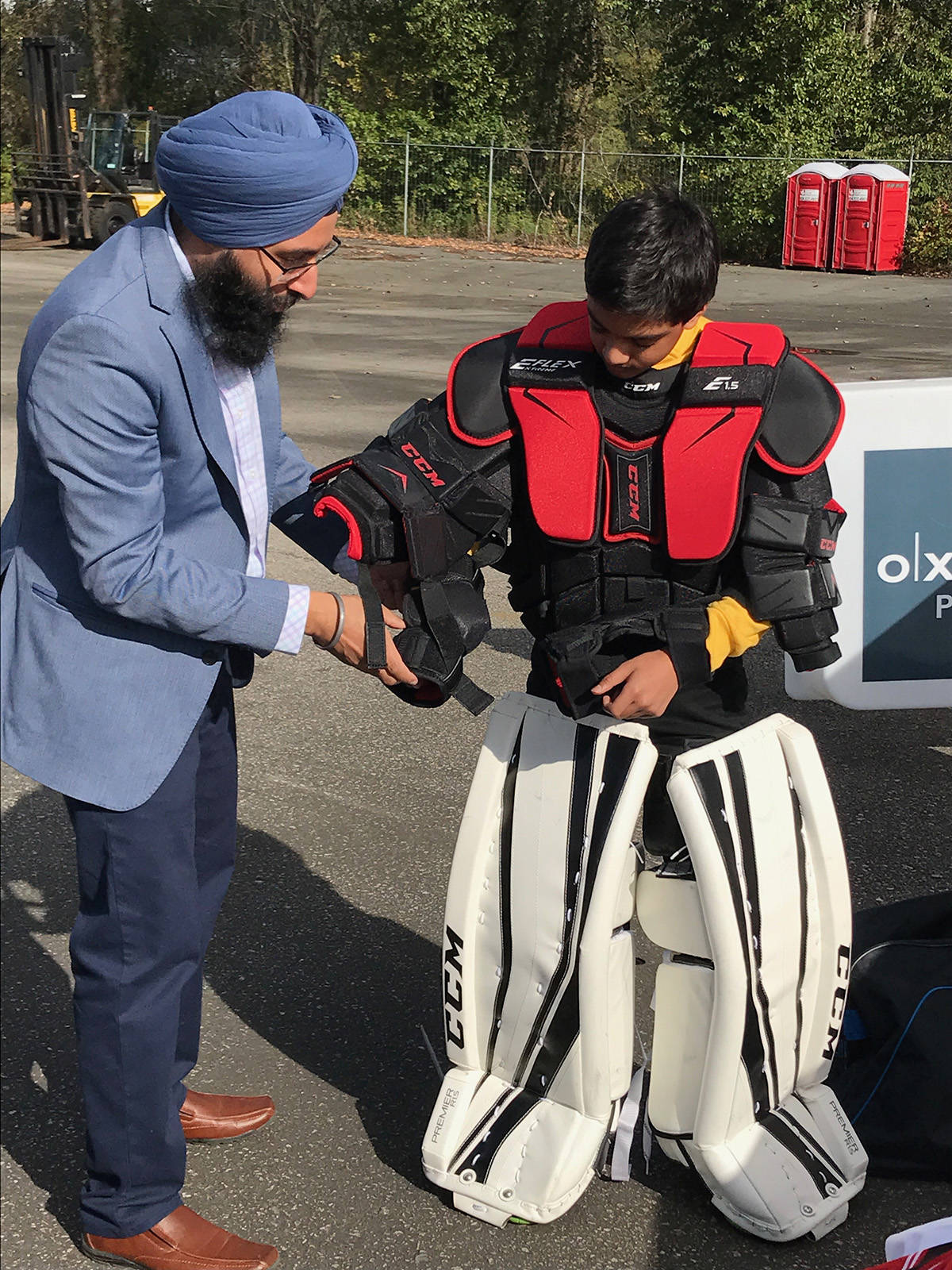 8611691_web1_Harnarayan-Singh-from-Hockey-Night-in-Canada-Punjabi-Edition-helps-Surrey-HEROS-hockey-kid-suit-up-as-goalie