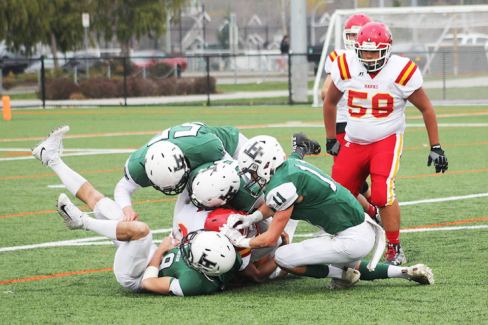 Lord Tweedsmuir football players swarm a lone W.J. Mouat Hawk Nov. 8. Lord Tweedsmuir won the game 57-7 and face the New West Hyacks in a playoff quarterfinal game Nov. 16. (Photo: Malin Jordan)