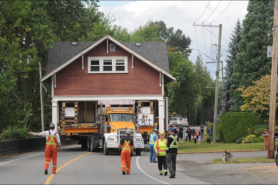 Crews with Nickel Bros move a 110-year-old heritage house along Hope River Road in Chilliwack on Friday, Aug. 7, 2020. The house was being relocated from 46239 Hope River Rd. to Riverside Drive that morning. (Jenna Hauck/ Chilliwack Progress)